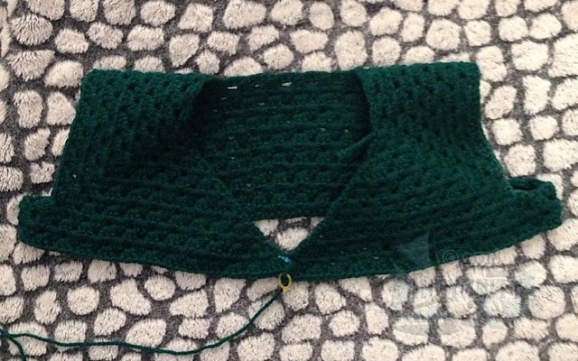 A green cardigan top, partially crocheted. Very large.