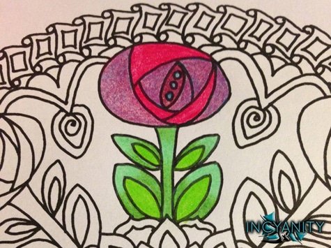 A closeup of a drawing of a stylized flower that has been colored with pencil crayons.